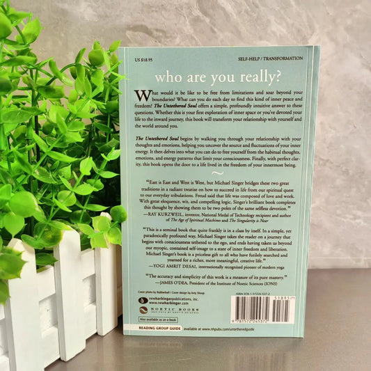 Book titled 'who are you really?' with a plant in the background